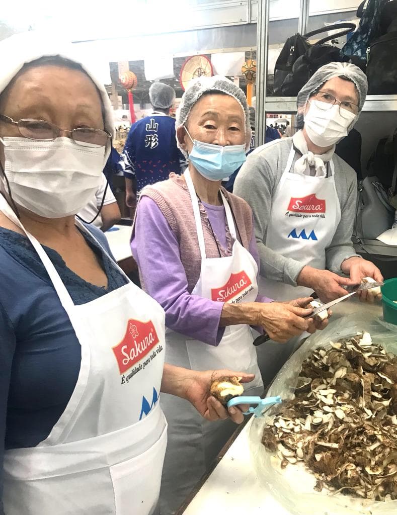 Voluntárias descascando taro para o preparo do imoni em 2022