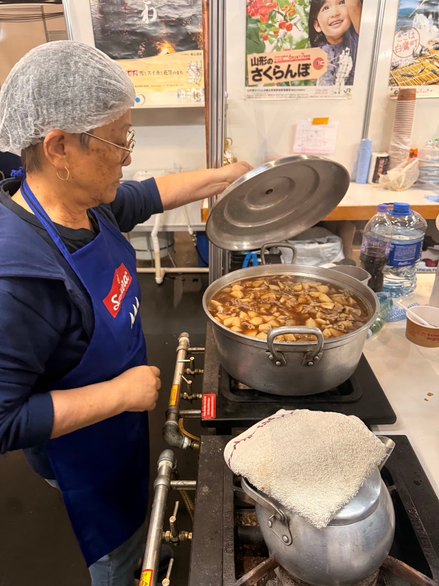 Voluntária mexendo a panela de imoni no estande da Yamagata em 2025