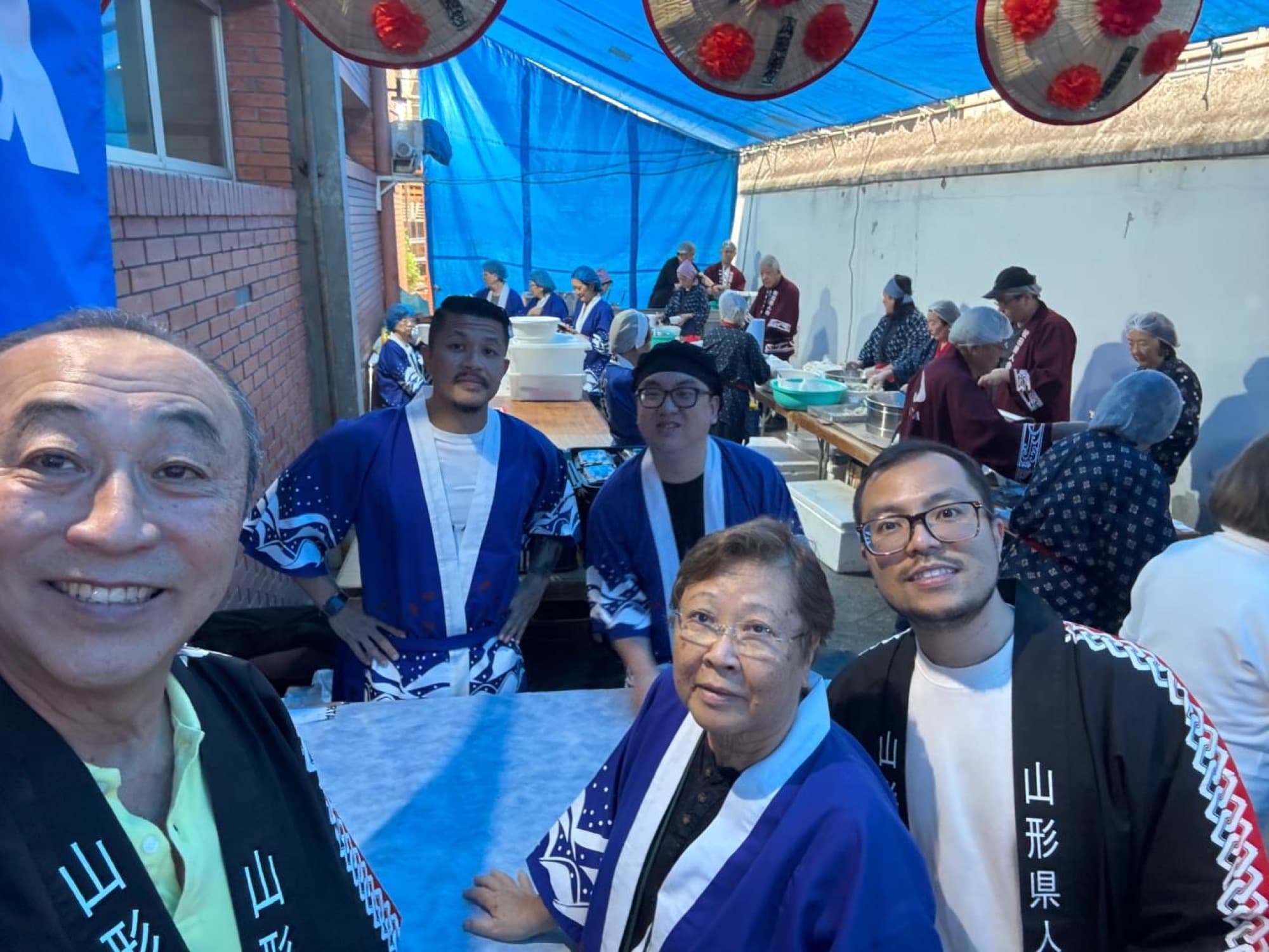 Grupo de associados da Yamagata Kenjin com a faixa 山形県人 durante o festival